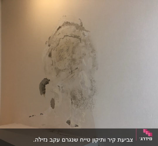 קיר עם תיקוני טיח וצבע מתקלף